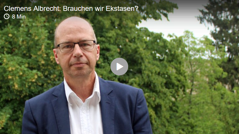 Eine Wissenschaftlerin und ein Wissenschaftler arbeiten hinter einer Glasfassade und mischen Chemikalien mit Großgeräten.